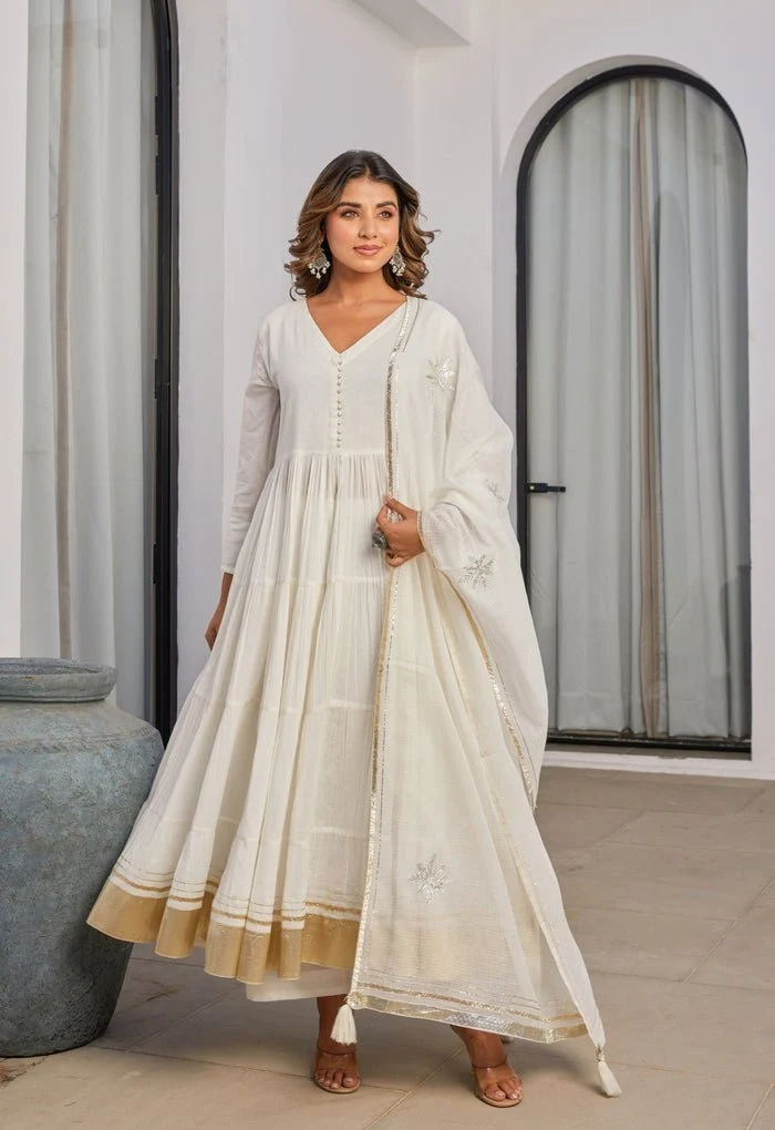 A graceful ivory Anarkali set featuring delicate embroidery, a flared silhouette, golden border detailing, and a matching dupatta for an elegant ethnic look. Your Style, Your Choice